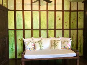 a bench with pillows in a room with a green wall at Posada La Patriciana in Taal