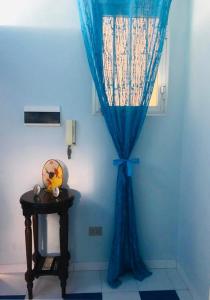 Habitación azul con cortina azul y mesa en Tremiti Home en Termoli