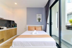 1 Schlafzimmer mit einem großen Bett und einer Küche in der Unterkunft Cozrum Homes - Saphera Residence in Ho-Chi-Minh-Stadt