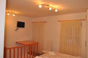 Schlafzimmer mit einem Bett, einem Schreibtisch und einem TV in der Unterkunft Apartments Lucic in Dubrovnik