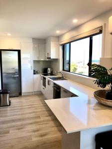a kitchen with white appliances and a large window at Kingscliff Holiday Rental in Kingscliff