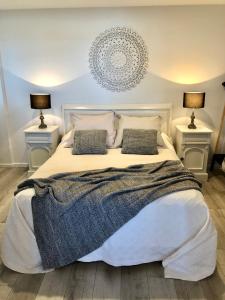 a bedroom with a large white bed with two lamps at Kingscliff Holiday Rental in Kingscliff