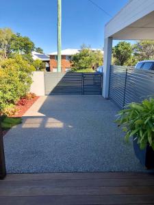 a driveway with a gate and stairs in front of a building at Kingscliff Holiday Rental in Kingscliff