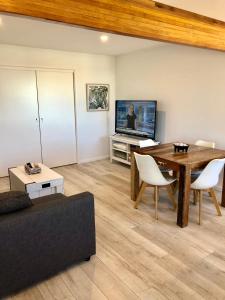 a living room with a table and a piano at Kingscliff Holiday Rental in Kingscliff