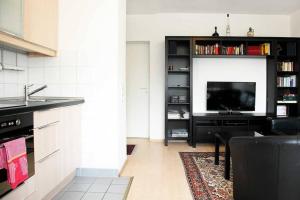 a living room with a kitchen with a tv and a counter at City Apartments Cologne - Apartment 2 in Cologne