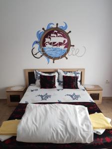 a bedroom with a bed with a crest on the wall at EL Capitano - Mamaia Nord in Mamaia Sat/Năvodari