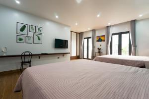 a hotel room with two beds and a flat screen tv at Tropical Villa Halong in Ha Long +31 photos