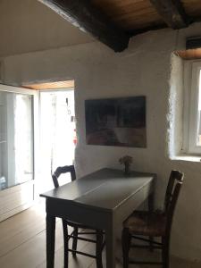 een tafel in een kamer met 2 stoelen en een raam bij Gîte Aghja suttana l'incantu in Santa-Lucia-di-Mercurio