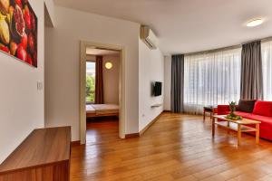 布德瓦的住宿－Montesun Apartments，客厅配有红色的沙发和桌子