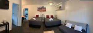 a living room with two couches and a television at Racecourse Motel in Paeroa +7 photos