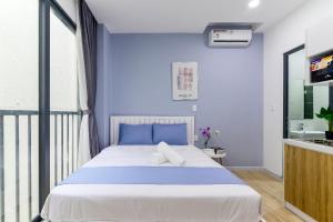 a bedroom with a large bed with blue walls at Cozrum Homes - Saphera Residence in Ho Chi Minh City