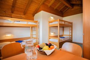 a bowl of fruit on a table in a room with bunk beds at Junges Hotel Zell am See in Zell am See