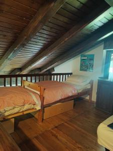 two beds in a room with wooden floors at Chalet Chamois in Courmayeur