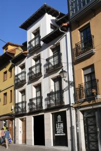 ein weißes Gebäude mit Balkonen und einem Schild darauf in der Unterkunft LEÓN SUITE Urban Studios in León