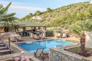 a swimming pool with chairs and a resort at Takis Studios in Punta