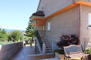 a bench sitting in front of a house with stairs at Apartamentos Os Cerros in Portonovo