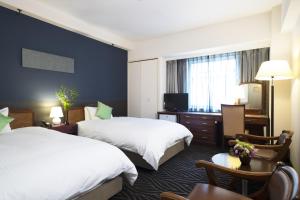 Postel nebo postele na pokoji v ubytování Kanazawa New Grand Hotel Prestige