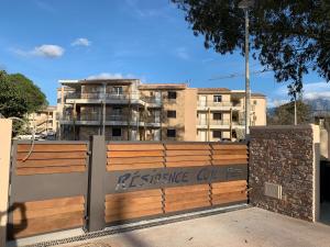 una recinzione di legno con un cancello con un edificio sullo sfondo di T2 neuf bord de plage - terrasse - CALVI a Calvi