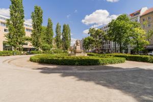a statue in a park with trees and buildings at SUITE & APART in Berlin