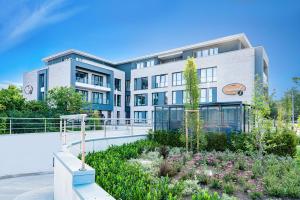 a building with a garden in front of it at Stadthotel Lohne, Self Check In, mit Bäckerei und Cafe in Lohne