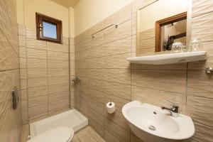 コイニラにあるPension Sotiriaのバスルーム(洗面台、トイレ、鏡付)