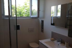 ein Badezimmer mit Waschbecken, Toilette und Spiegel in der Unterkunft Suite sur la mer Marseille Corniche in Marseille + 25 Fotos