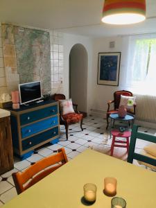a living room with a blue dresser and chairs at Le Rez de Jardin in Illkirch-Graffenstaden