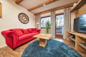 - un salon avec un canapé rouge et une télévision dans l'établissement Landhotelwohnung in Seeg, à Seeg