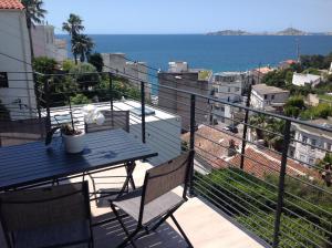 balcón con mesa y vistas al océano en Suite sur la mer Marseille Corniche en Marsella