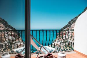 Un balcón con sillas y vistas al océano. en Alcione Residence en Positano