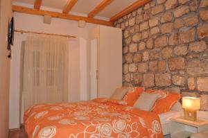 a bedroom with a stone wall and a bed at Apartments Lucic in Dubrovnik