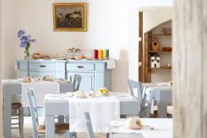 a dining room with white tables and white chairs at Masseria Borgo Mortella in Lecce