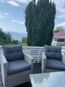 two wicker chairs and a table on a patio at Moldegaard Farmhouse - Apartment A in Moldegard