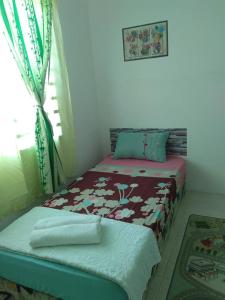 a small bedroom with a bed and a window at Alif Homestay Changlun in Changlun