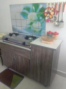 a kitchen with a stove and a counter top at Alif Homestay Changlun in Changlun