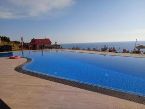 a large blue swimming pool next to the ocean at Appartamento Taggiasca a Riva Trigoso in Sestri Levante