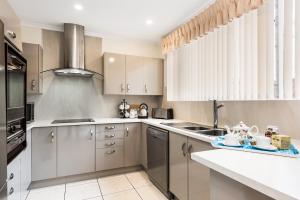 a kitchen with stainless steel appliances and white cabinets at Adelaide Style Accommodation-Close to City-North Adelaide-3 Bdrm- FREE Parking in Adelaide