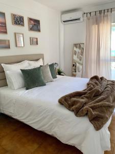 a bedroom with a white bed with a blanket on it at Albufeira Bran House in Albufeira
