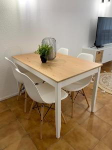 a wooden table with chairs and a potted plant on it at Albufeira Bran House in Albufeira