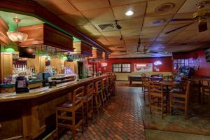 a restaurant with a bar with wooden chairs at Ramada by Wyndham Macon in Macon