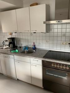 a kitchen with white cabinets and a sink at kuscheliges Marburg in Marburg an der Lahn