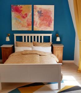a bedroom with a white bed and blue walls at FerienNest Haus Braunfels in Bad Ems
