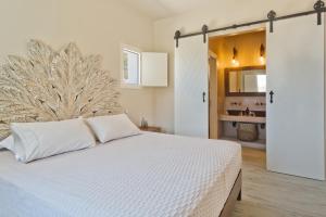 a bedroom with a white bed and a bathroom at Lux View Suites in Kyra Panagia