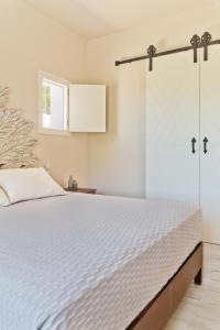 Schlafzimmer mit einem Bett und einer Glasschiebetür in der Unterkunft Lux View Suites in Kyra Panagia