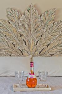 a bottle of alcohol on a tray with two glasses at Lux View Suites in Kyra Panagia