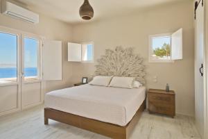 a bedroom with a bed and two windows at Lux View Suites in Kyra Panagia
