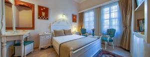 a bedroom with a bed and a desk and chairs at La Paloma Hotel in Antalya