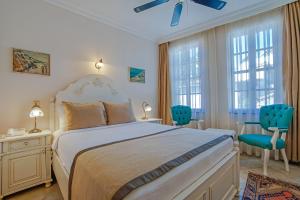 a bedroom with a large bed and two blue chairs at La Paloma Hotel in Antalya