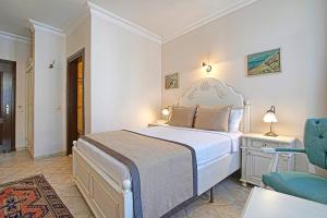 a bedroom with a bed and a blue chair at La Paloma Hotel in Antalya