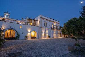 a large white house with a driveway at night at Masseria Borgo Mortella in Lecce